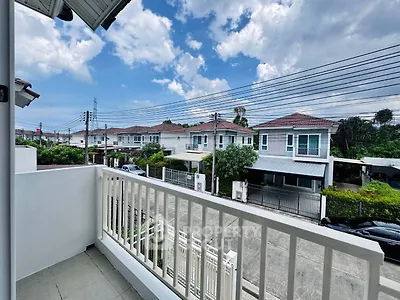 Charming suburban view from a cozy balcony overlooking modern homes under a clear blue sky.