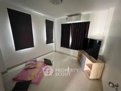Minimalist living room with TV and floor seating, ideal for cozy relaxation.