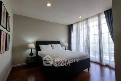 Spacious bedroom with large windows and elegant decor, perfect for relaxation and comfort.