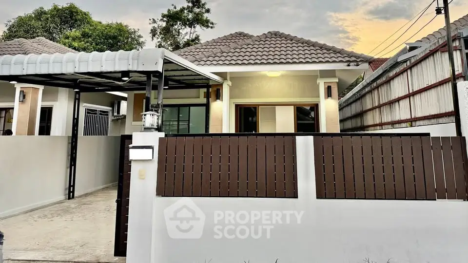 Charming single-story home with modern facade and gated driveway in serene neighborhood.