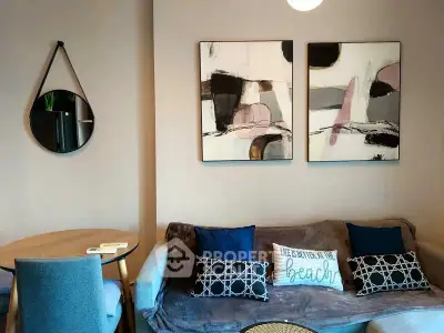 Stylish living room with modern art and cozy seating in a contemporary apartment.
