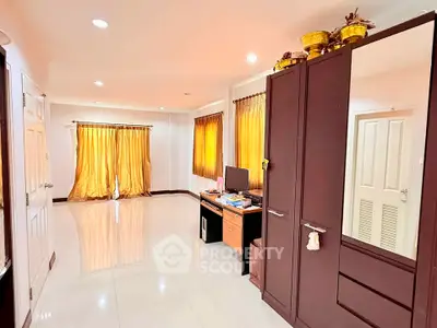 Spacious room with elegant curtains and modern furniture, perfect for a stylish home office setup.