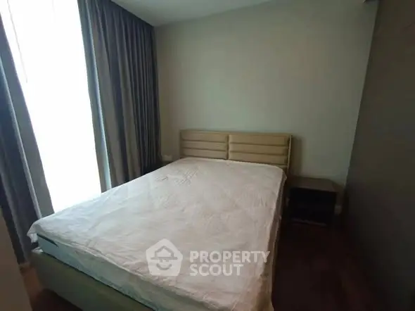 Cozy bedroom with natural light and modern furnishings in a stylish apartment.