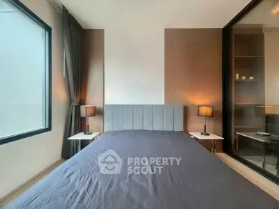 Modern bedroom with stylish decor and large window offering natural light
