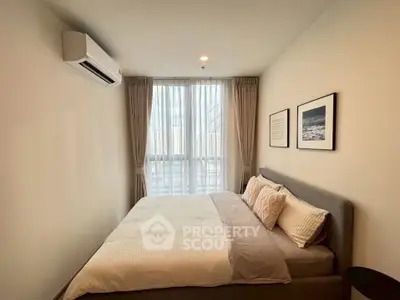 Cozy bedroom with large window and modern decor in a stylish apartment.