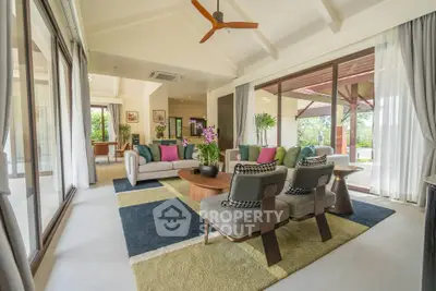 Spacious living room with modern decor and large windows offering garden views.