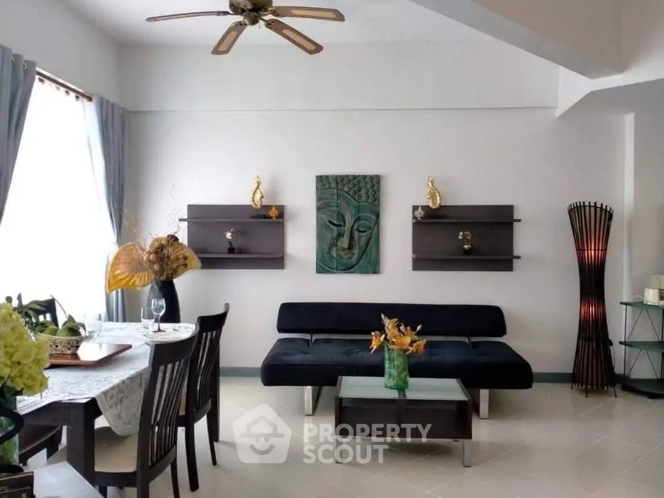 Elegant living room with modern decor and dining area, featuring stylish furniture and artistic wall accents.