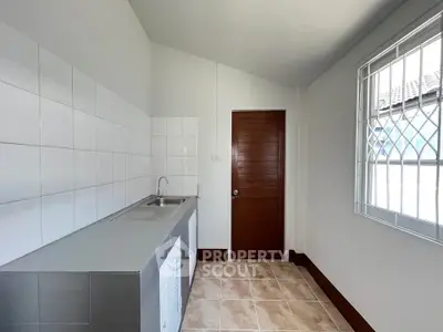 Modern kitchen with sleek design, featuring tiled backsplash and stainless steel sink, perfect for culinary enthusiasts.