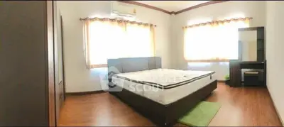Spacious bedroom with large windows and modern furnishings, perfect for comfort and relaxation.
