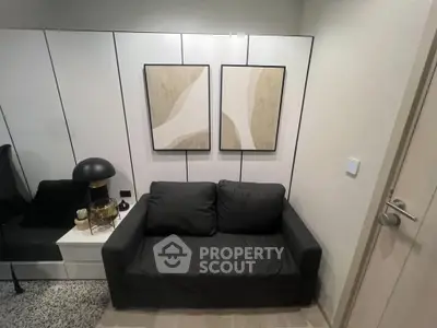 Modern living room with stylish black sofa and abstract art on wall