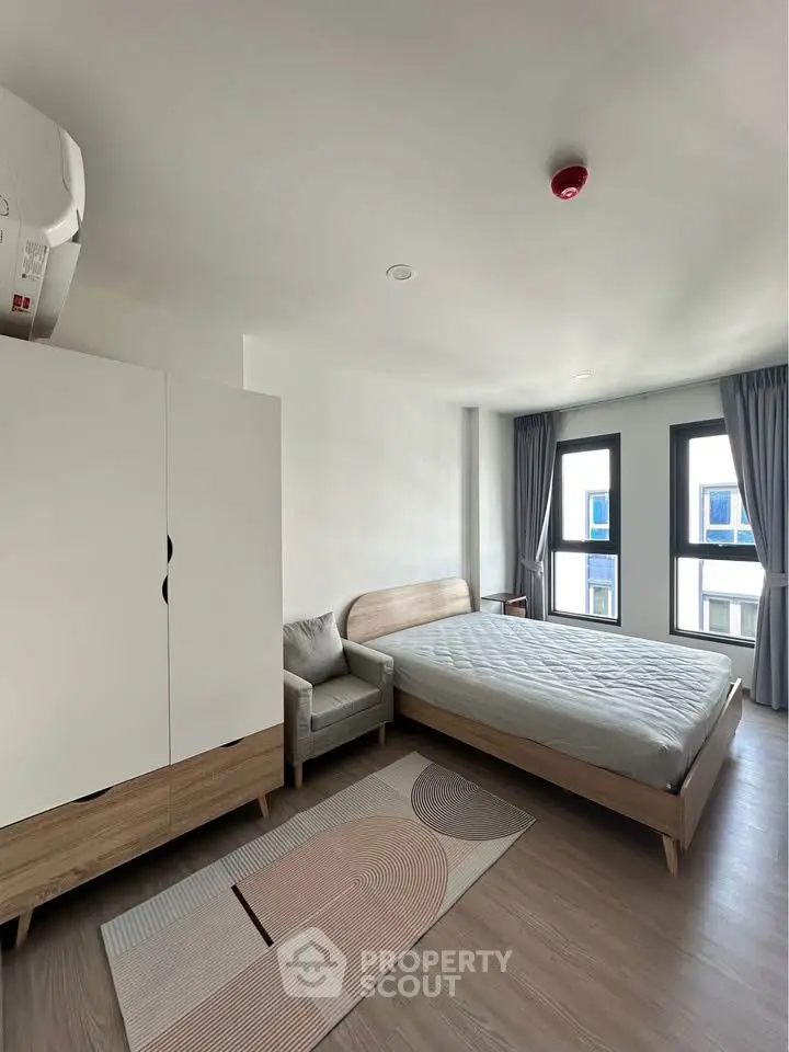 Modern bedroom with minimalist design, featuring a cozy bed, stylish wardrobe, and large windows.