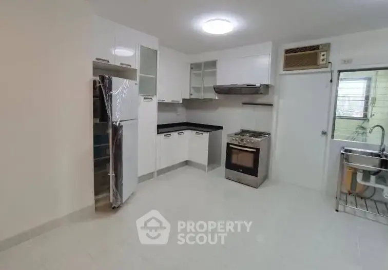 Modern kitchen with sleek cabinets, gas stove, and stainless steel appliances in a bright, spacious layout.