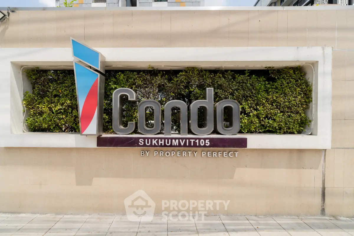 Modern condo entrance sign with lush greenery at Sukhumvit 105, perfect urban living.