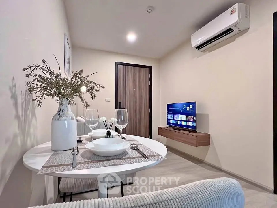 Modern living room with dining area, featuring air conditioning and stylish decor.