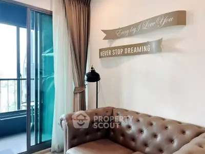 Chic living room with elegant sofa and inspiring wall decor, adjacent to a glass balcony door.