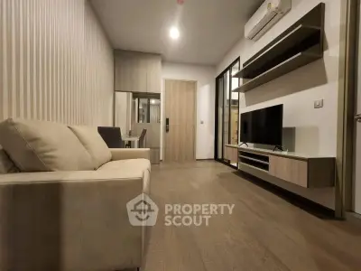 Modern living room with sleek furniture and wall-mounted TV in a stylish apartment.