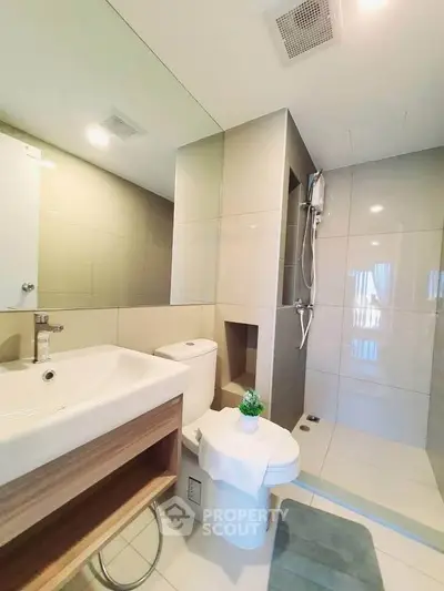 Modern bathroom with sleek design, featuring a spacious shower and elegant fixtures.