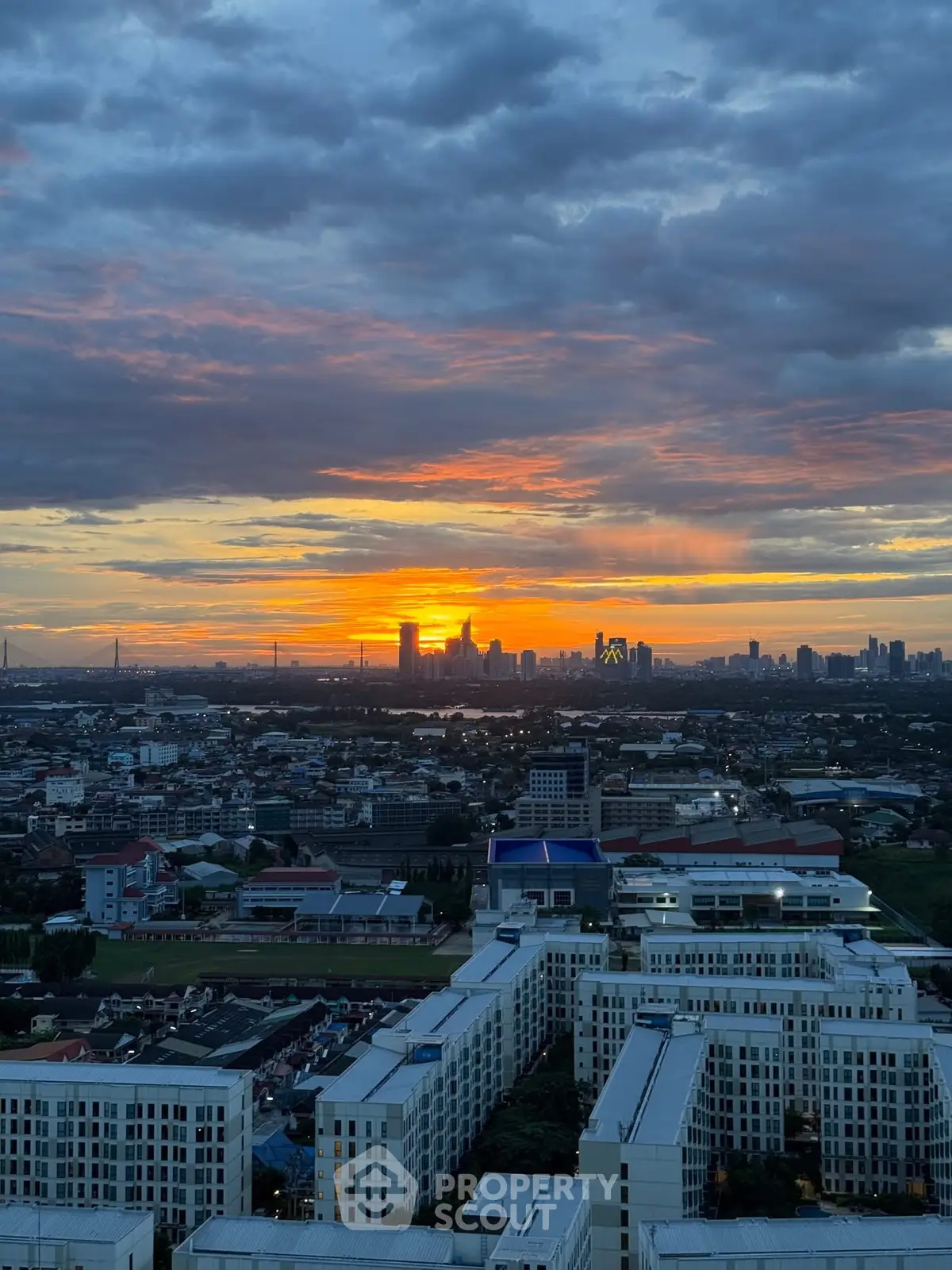 Stunning cityscape view at sunset with vibrant sky over modern buildings.