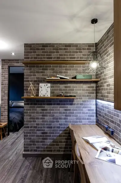 Stylish study area with brick wall, wooden shelves, and modern lighting in a cozy home interior.