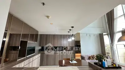 Modern open-layout kitchen with sleek cabinetry and dining area in a stylish apartment