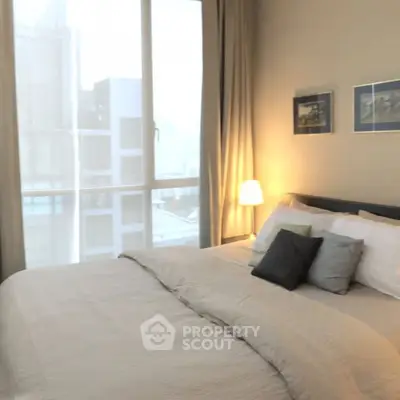 Cozy bedroom with large window and stylish decor in modern apartment