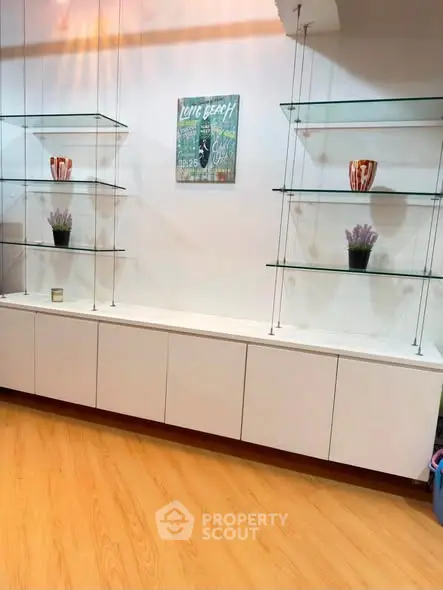 Modern interior with sleek glass shelves and wooden flooring, perfect for stylish home decor.