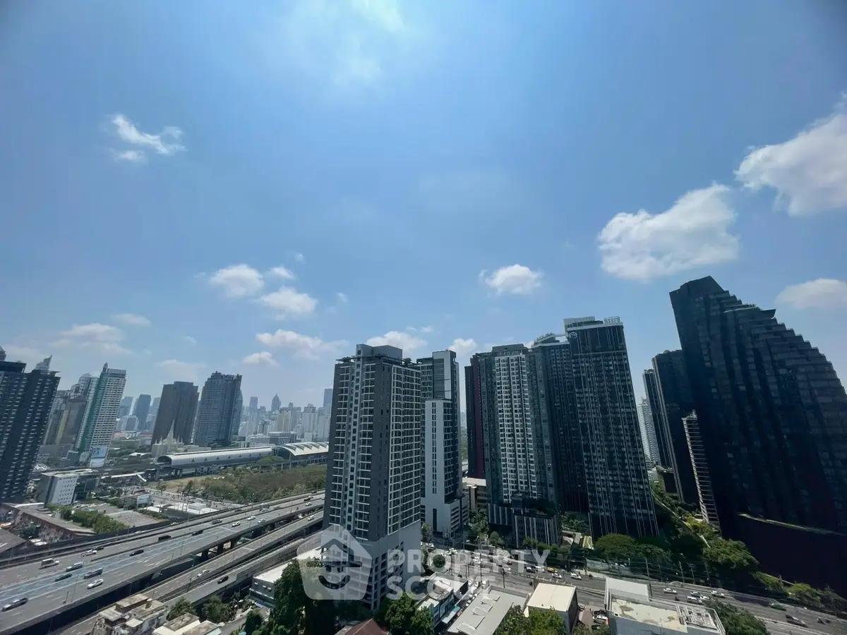 Stunning cityscape view of modern high-rise buildings under a clear blue sky, perfect for urban living.