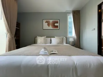 Cozy bedroom with modern decor and natural light, perfect for relaxation.