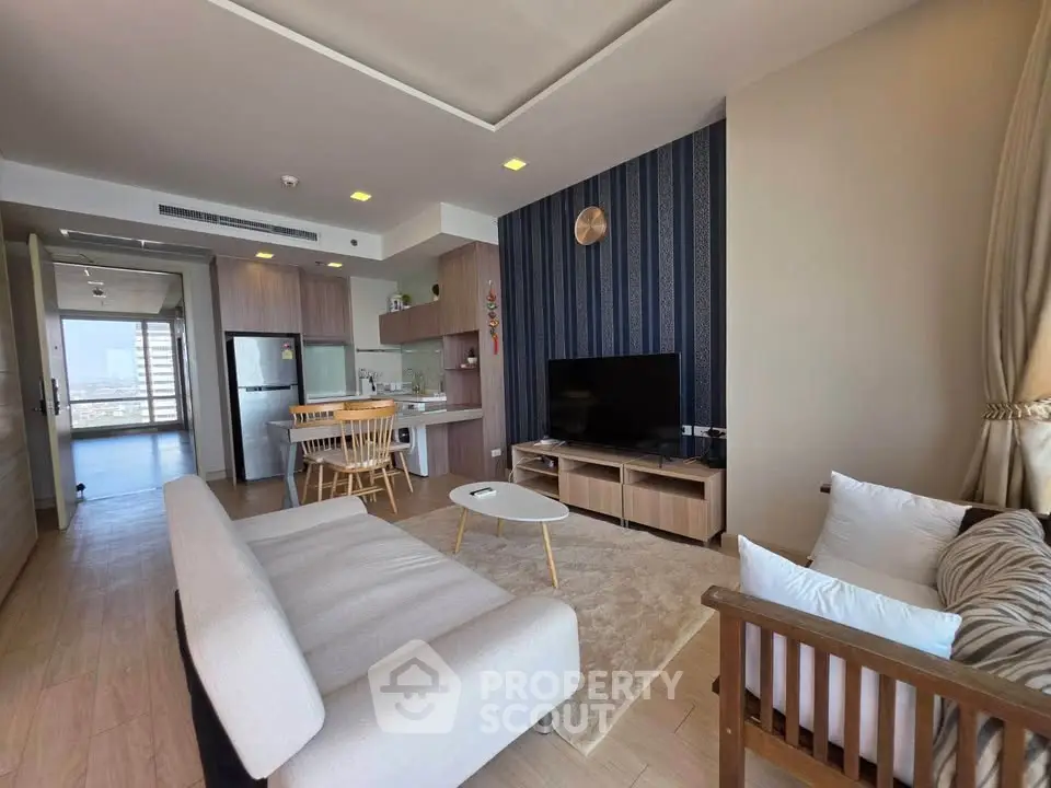 Spacious modern living room with open kitchen and stylish decor in high-rise apartment.