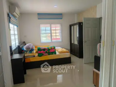 Spacious bedroom with modern furnishings and natural light, perfect for comfort and relaxation.