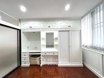 Spacious bedroom with elegant built-in wardrobe and hardwood flooring