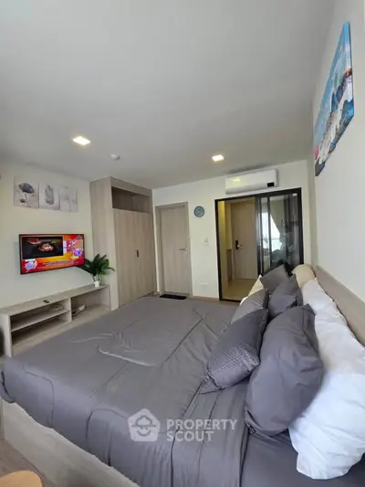 Modern bedroom with stylish decor and cozy bedding in a contemporary apartment.