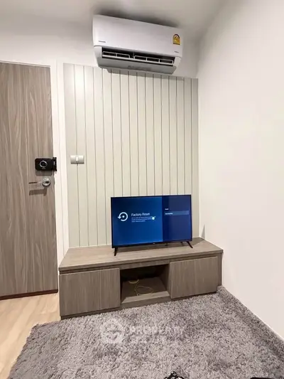 Modern living room with air conditioning and sleek TV setup, perfect for cozy relaxation.