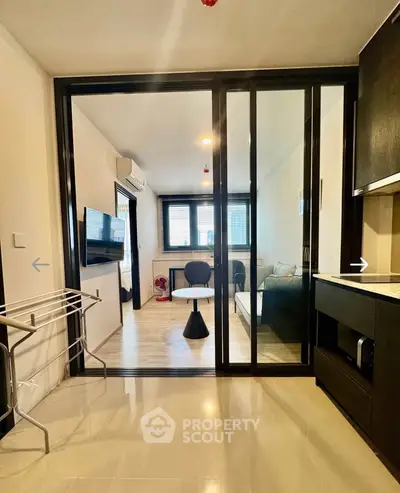 Modern living room with glass sliding doors and sleek furnishings in a contemporary apartment.