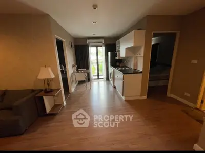 Cozy apartment interior with open kitchen and living area, featuring modern appliances and wooden flooring.