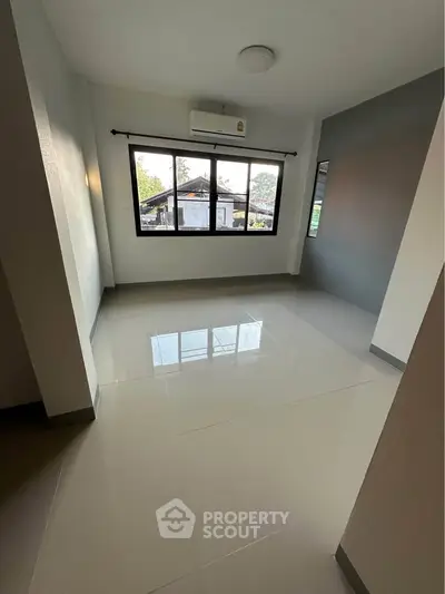 Spacious empty room with large windows and glossy tiled floor, perfect for customization.