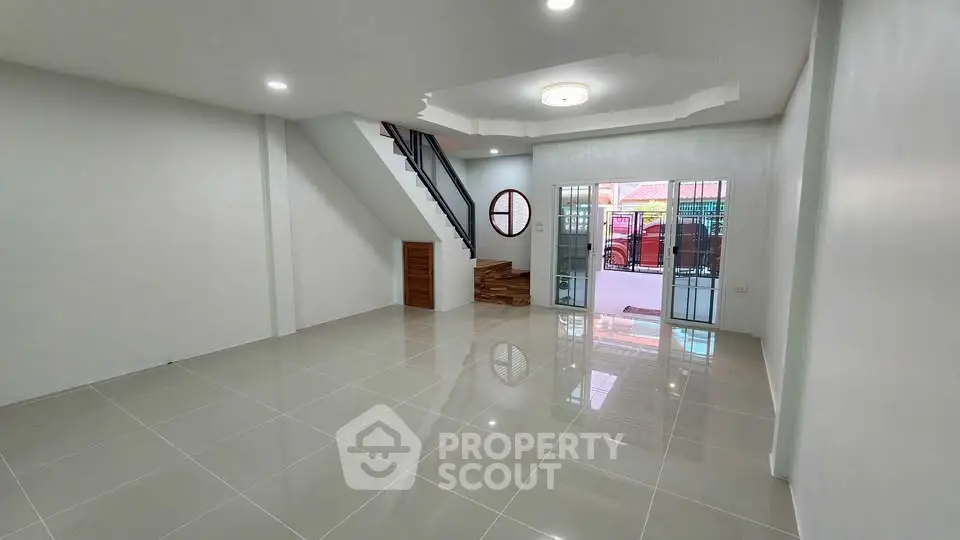 Spacious modern living room with glossy tile flooring and stylish staircase