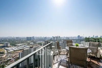Stunning high-rise balcony with panoramic city skyline view, perfect for relaxation.