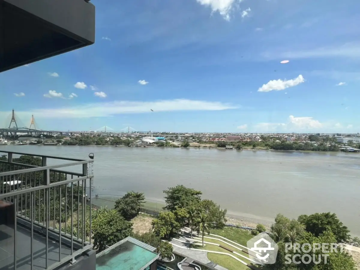 Stunning river view from high-rise balcony with cityscape and bridge in the background.