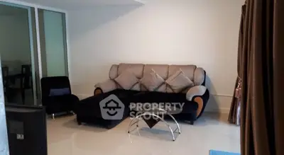 Cozy living room with modern sofa and glass coffee table in stylish apartment.