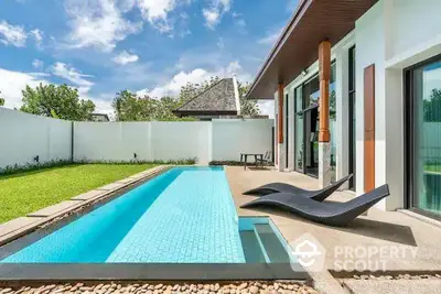 Luxurious modern villa with private pool and sun loungers in a serene garden setting.