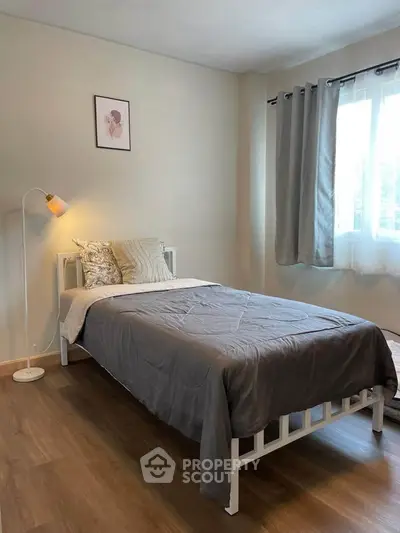 Cozy bedroom with single bed and modern decor, perfect for relaxation.