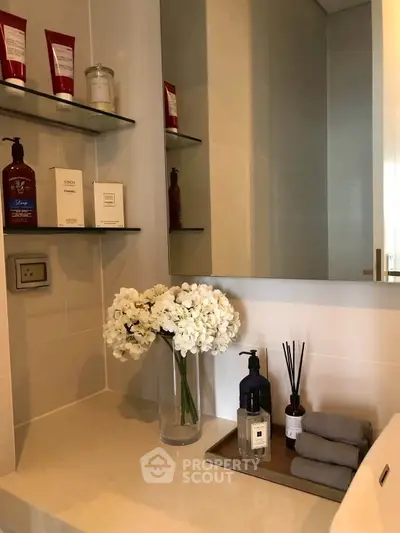 Elegant bathroom vanity with floral decor and luxury toiletries