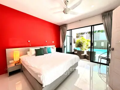 Spacious bedroom with pool view and vibrant red accent wall, perfect for relaxation.