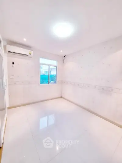 Spacious empty room with large window and air conditioning unit