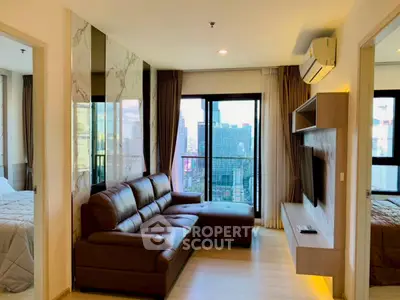 Modern living room with city view, featuring a leather sectional sofa and wall-mounted TV.