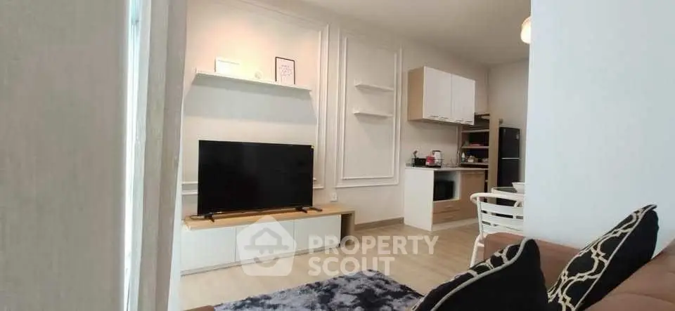 Modern living room with stylish decor and open kitchen layout in a cozy apartment.