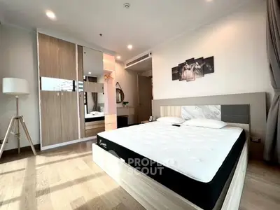 Spacious modern bedroom with stylish decor and ample natural light