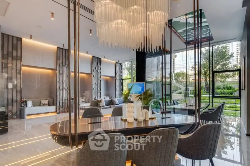 Luxurious modern living room with elegant chandelier and floor-to-ceiling windows offering garden views.