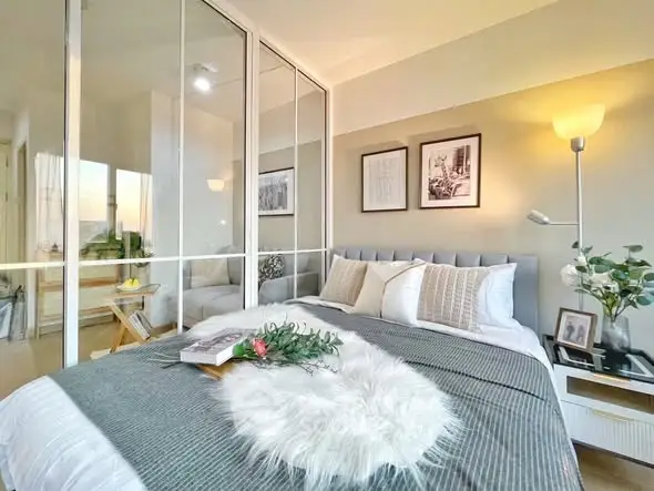 Modern bedroom with elegant decor and large glass windows offering natural light.